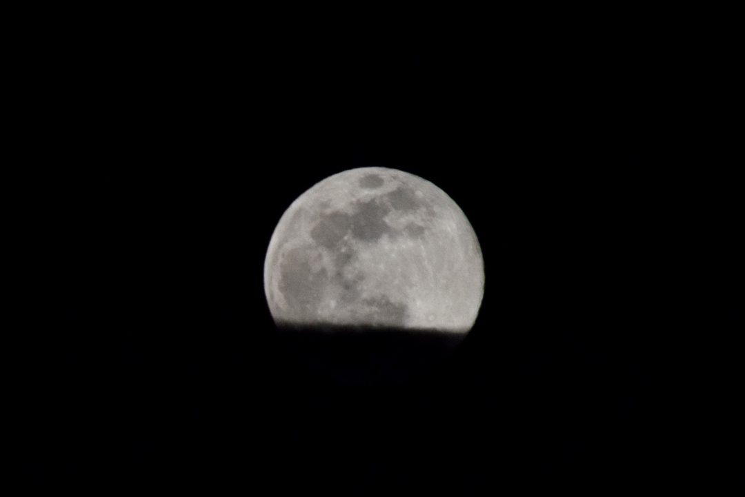 Rising Pink Moon, partially obscured by clouds